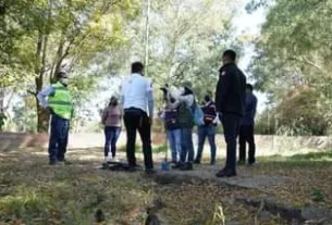 May be an image of 7 people, people standing, grass and tree
